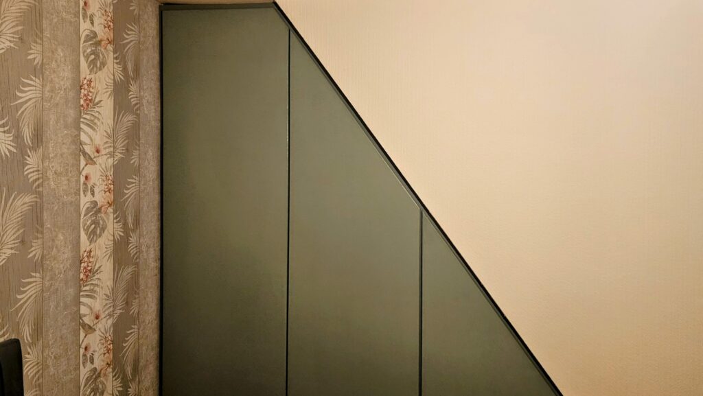 Bespoke under-stairs wardrobe with clean fitted panel design