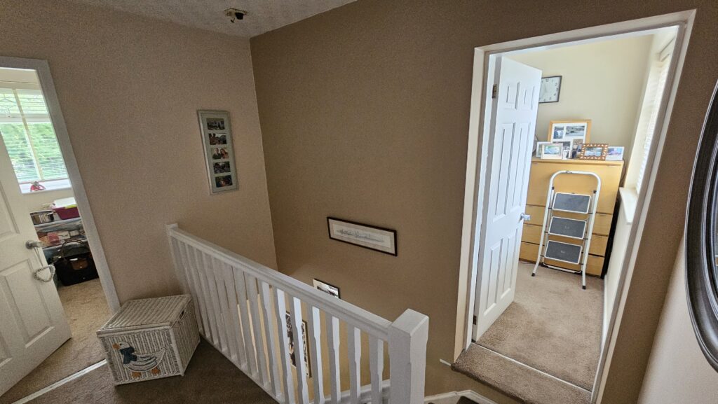 Finished upstairs landing and stairwell with fresh paintwork, white balustrade and clean lines
