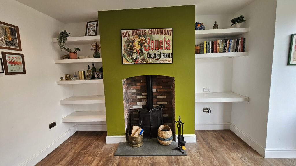Original fireplace wall with open shelving before media wall renovation and new storage cupboards