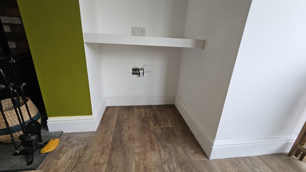 Original lower shelving area beside the fireplace before media wall storage cupboards were added