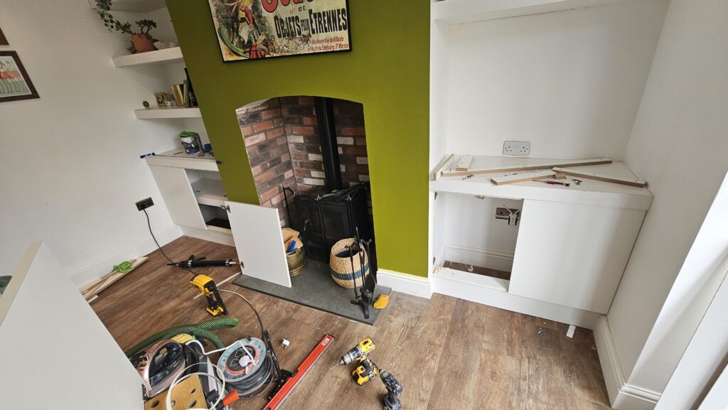 Media wall storage cupboards being installed beside the fireplace during renovation