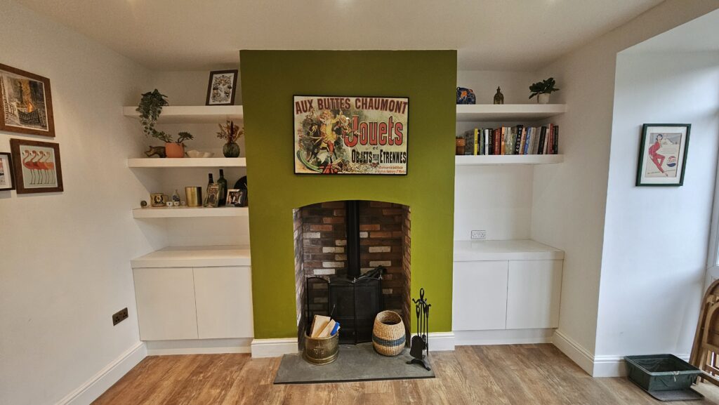 Completed media wall renovation with fitted shelving, four lower storage cupboards and feature fireplace