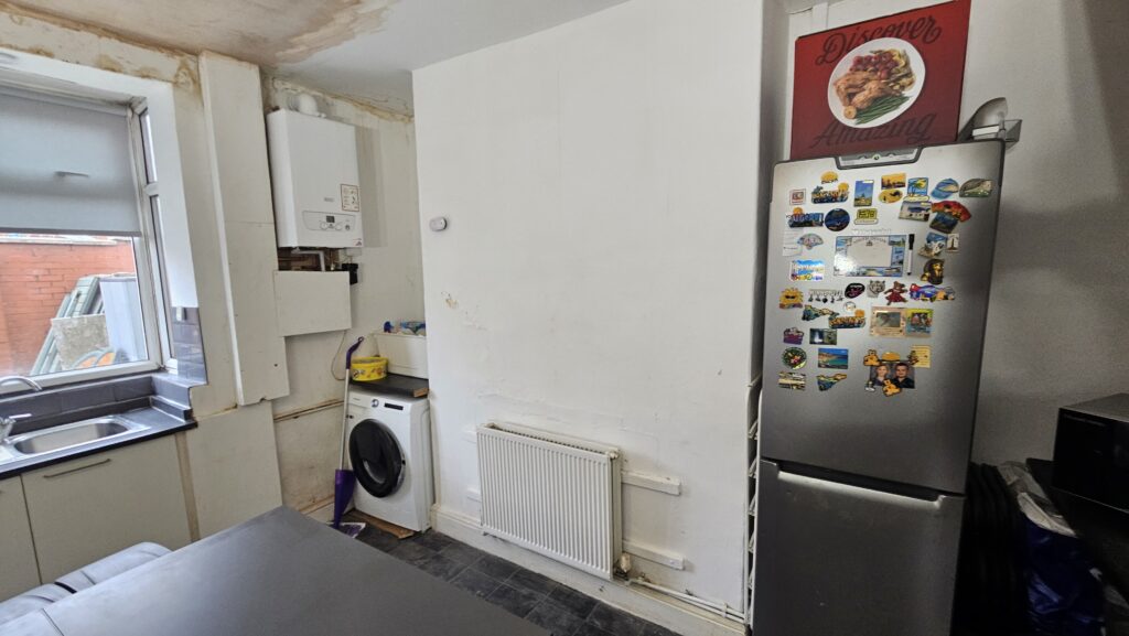 Kitchen before refurbishment showing unfinished walls, exposed boxing area and preparation work