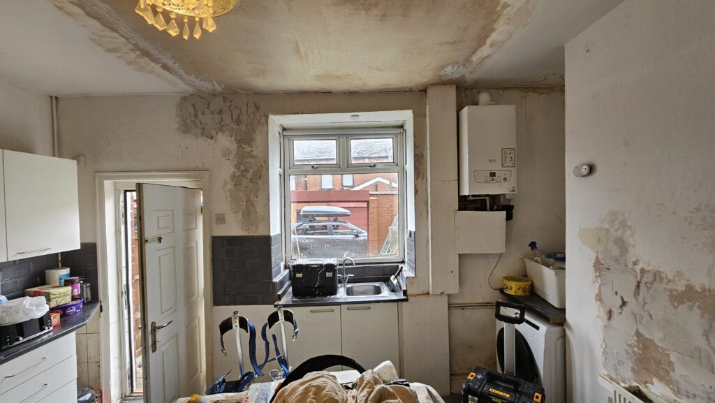Kitchen during refurbishment with damaged ceiling and walls prepared for plastering and painting