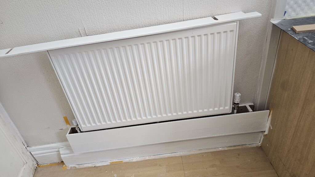 Custom radiator pipe boxing in progress with open access panel for future inspection and maintenance
