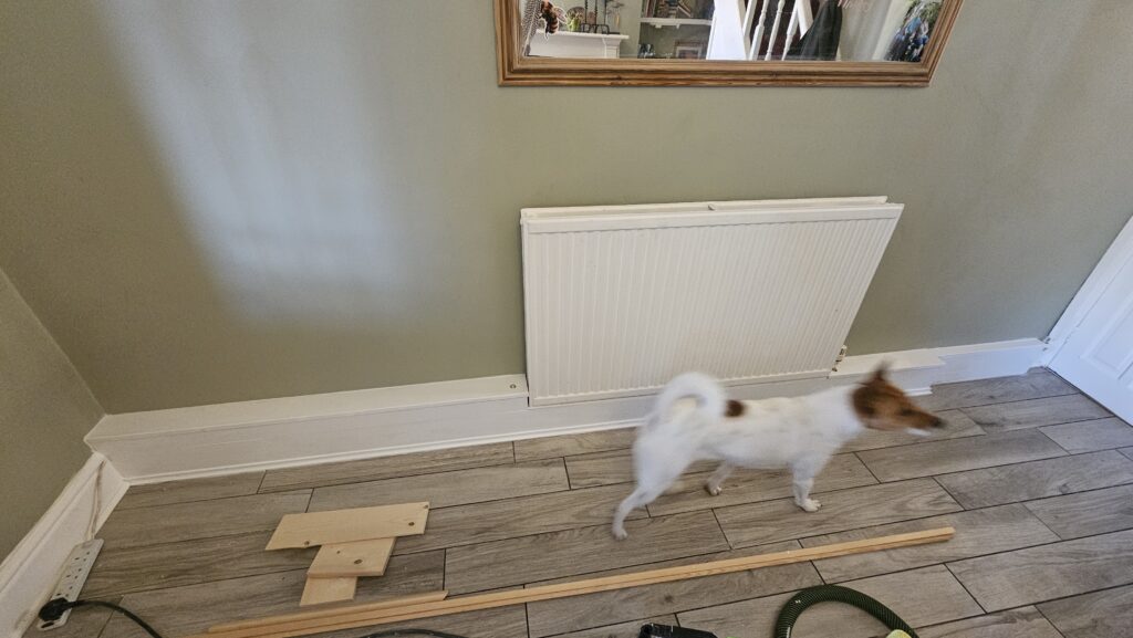 Radiator pipe boxing project in progress with materials prepared along the skirting line
