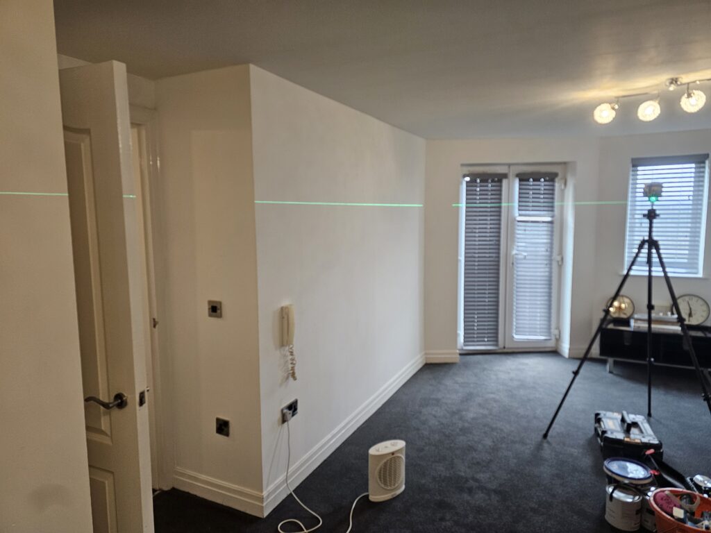 Living room painting project in progress with wall preparation and layout marking
