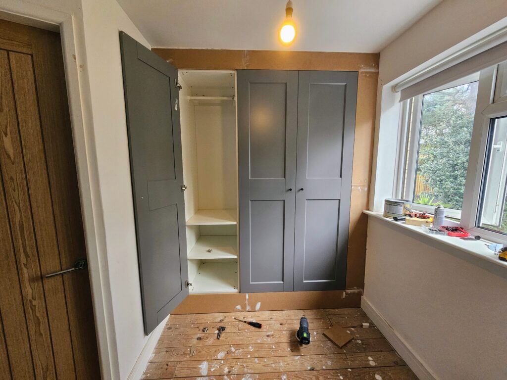 Built-in wardrobe boxing panels installed around IKEA PAX units to create a seamless fitted wardrobe appearance