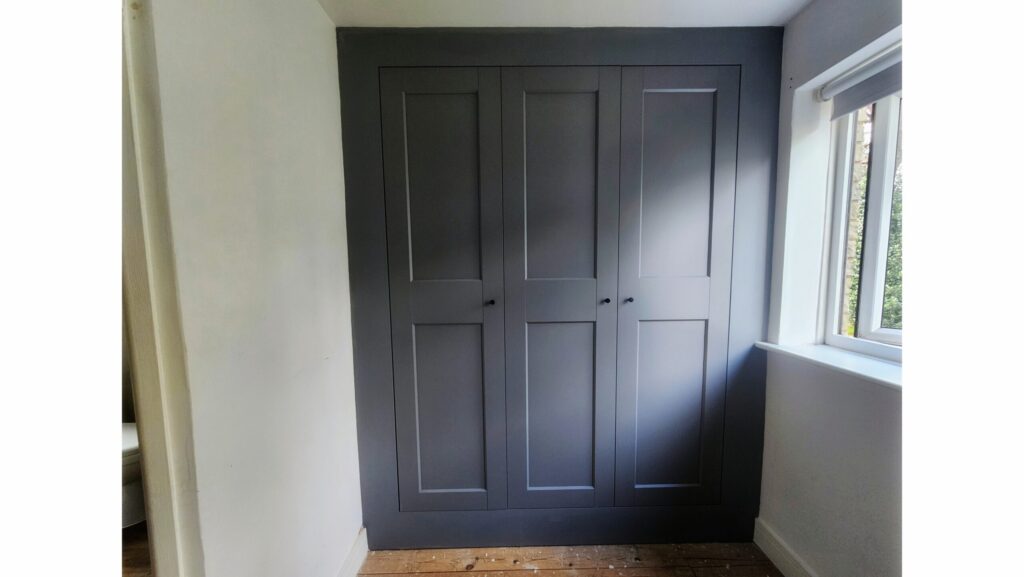 Custom built-in wardrobe created from IKEA PAX units with colour matched finish