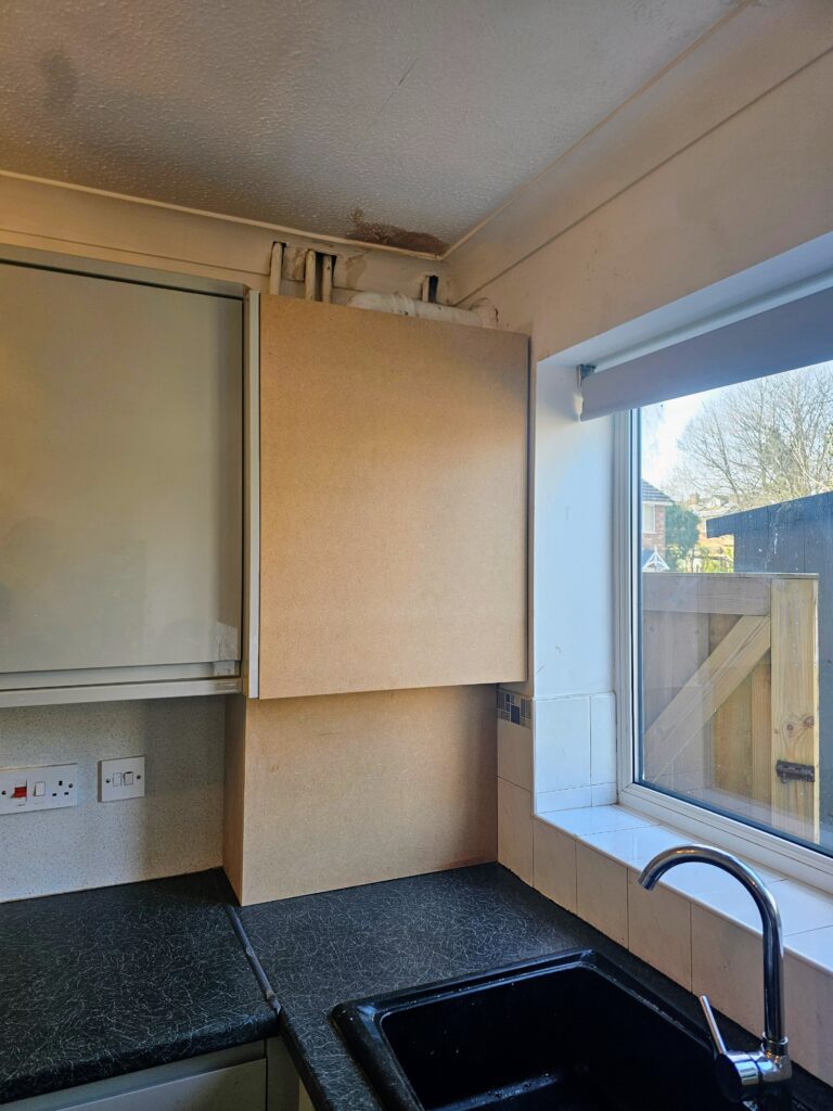 Finished MDF boiler boxing in a kitchen corner above the worktop, ready for painting.