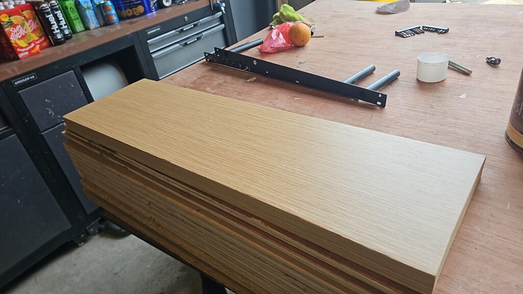 Wood-veneered kitchen shelf boards ready for edge sanding and final finishing.