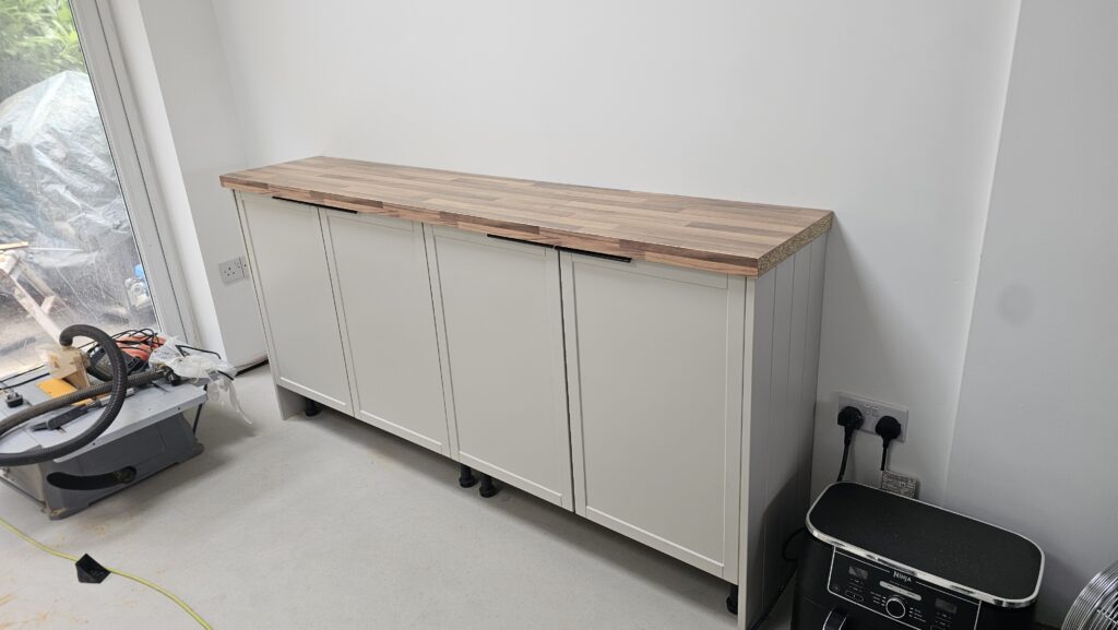 Finished walnut-effect laminate worktop installed on bespoke shaker base cabinets