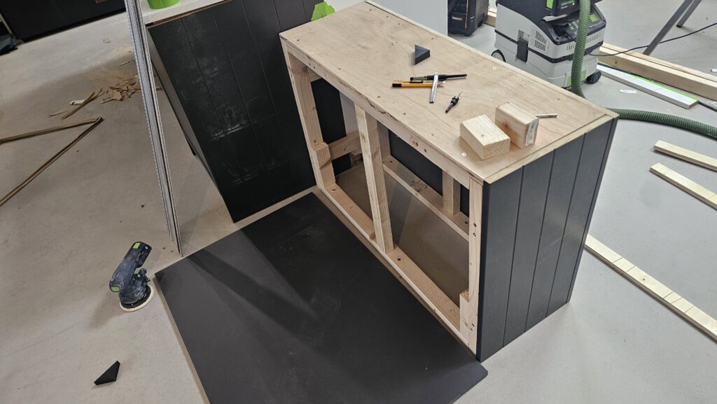 Installing decorative black panels onto a custom-built timber kitchen island frame