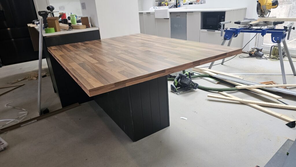 Custom walnut dining table integrated with a bespoke kitchen island