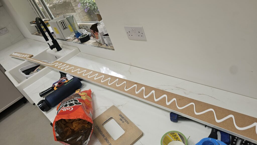 Installing a marble-effect kitchen upstand using grab adhesive to create a neat waterproof finish
