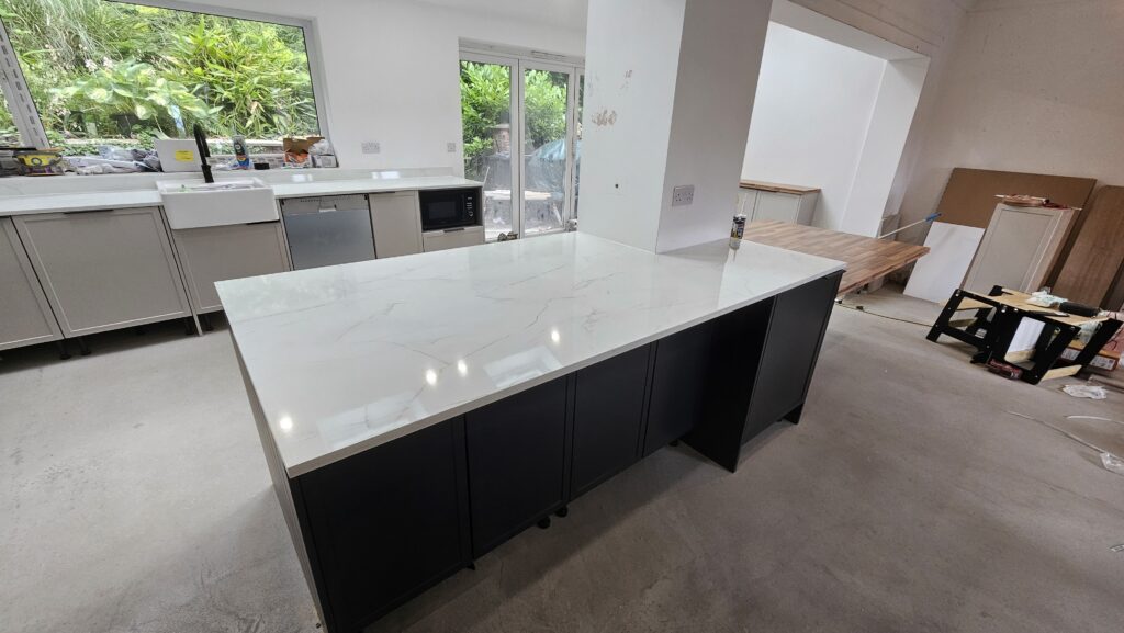 Completed bespoke kitchen island with marble-effect worktop and black shaker panelling