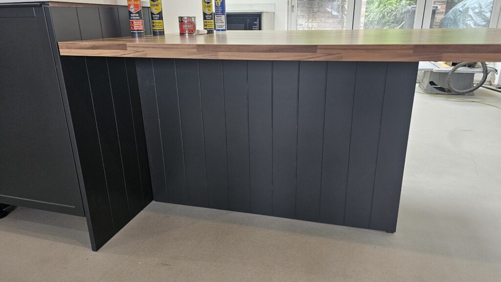 Completed bespoke walnut-effect dining table seamlessly integrated with the kitchen island