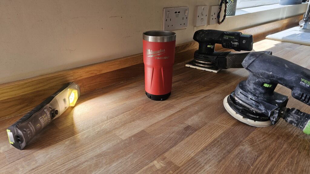 Festool sanders and inspection light set up on a solid oak kitchen worktop during the restoration process.