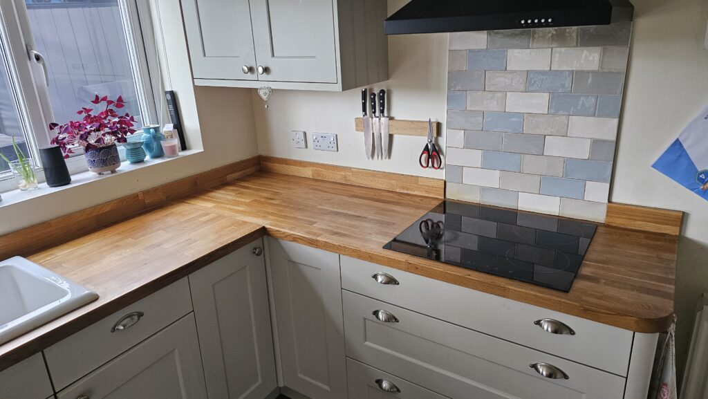 Restored solid oak kitchen worktop around the hob after sanding and refinishing with hard wax oil.