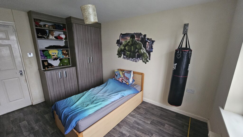 Original bedroom before bespoke Hulk themed renovation with existing Hulk wall decal and punching bag