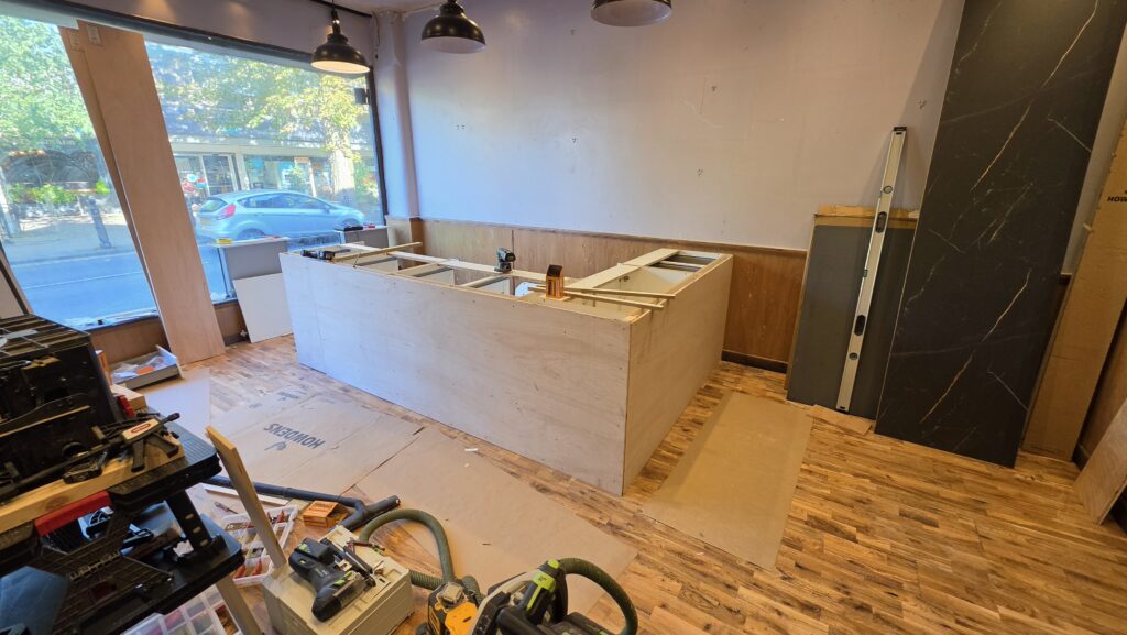 Plywood fitted to the outside of the café counter cabinets ready for tiling