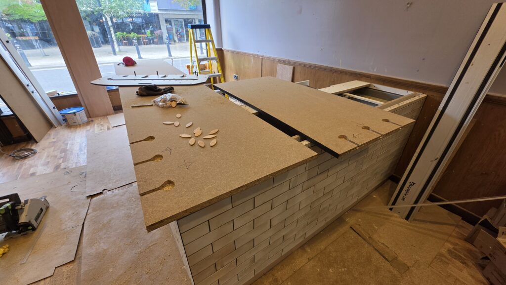 Installing and positioning the black worktop on the bespoke café counter