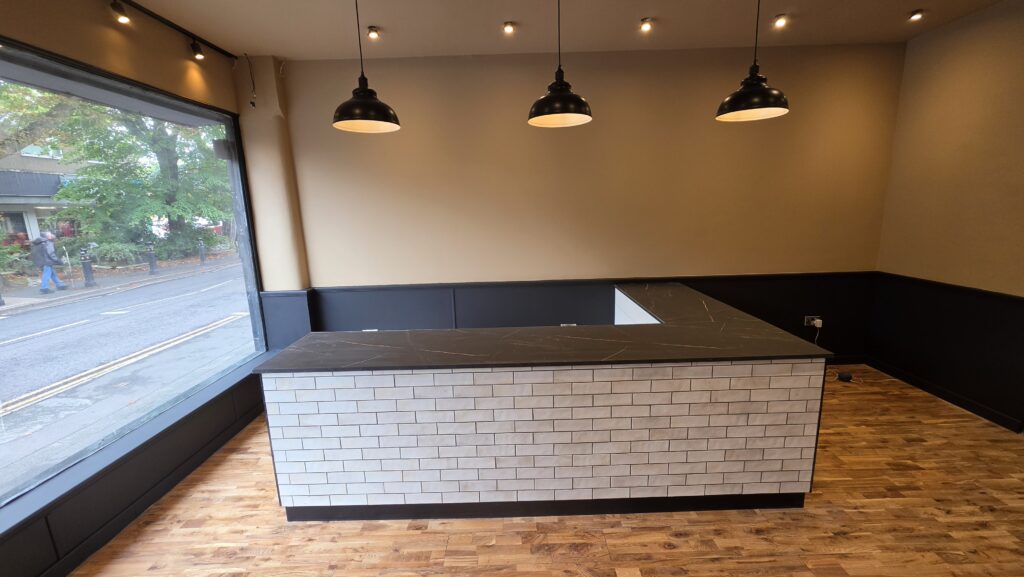 Completed bespoke café counter with white brick tiles and black worktop